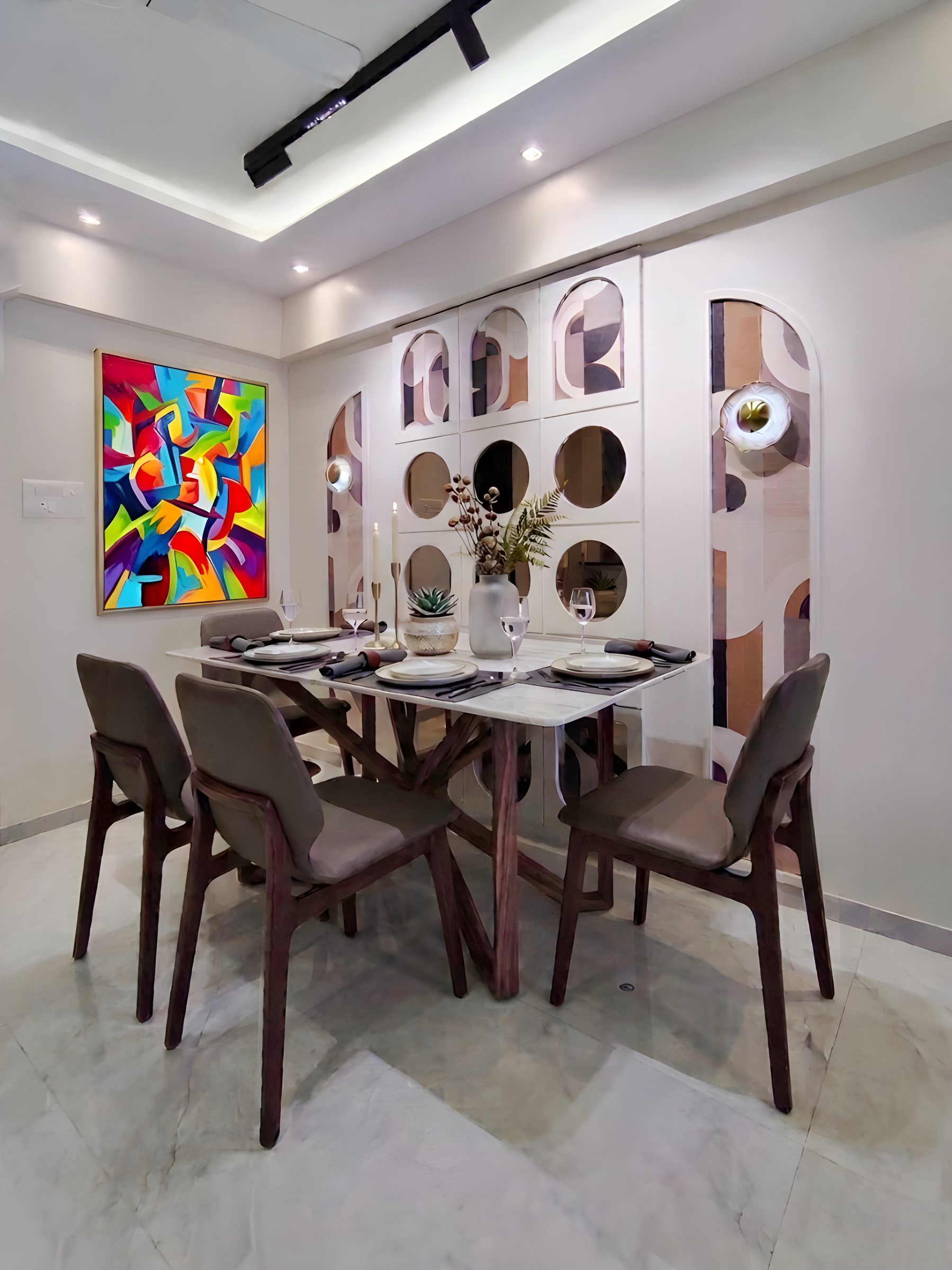 Dining room by Ranzospace Mumbai with mirror wall and colour art